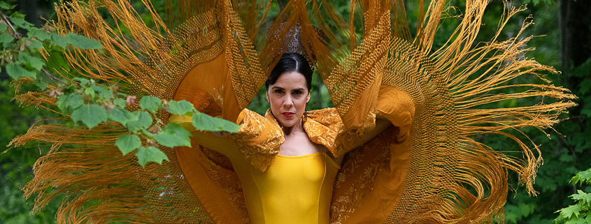Irene Rodriguez in yellow with arms extended.